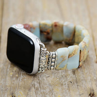 Smartwatch with a decorative band on a wooden surface. Earthy Jasper Stretchy Apple Watch Band | ALLORA JADE