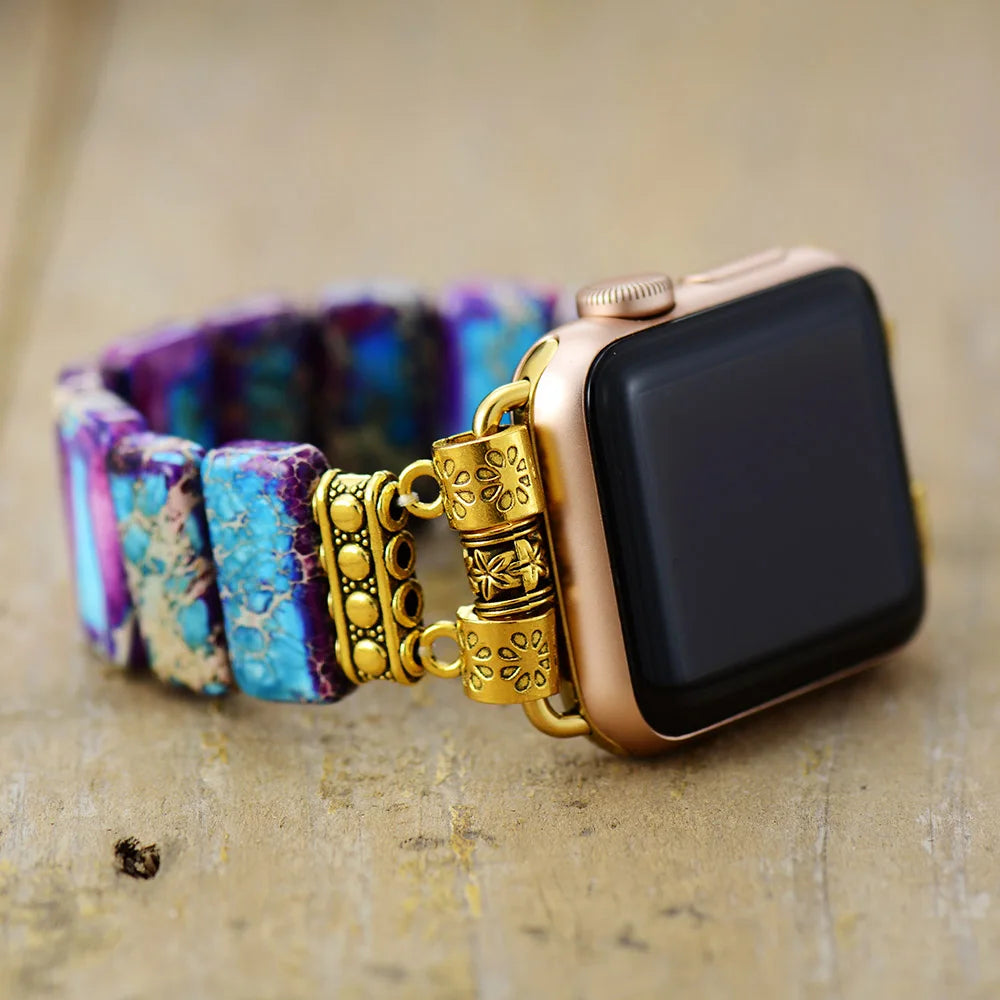 Smartwatch with a decorative gold band on a textured surface. Purple Aqua Jasper Stretchy Apple Watch Band - gold | ALLORA JADE