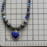 Close up of Jasper & Lapis Lazuli Heart Charm Wrap Bracelet–Necklace on size chart showing detailed bead mix and blue heart pendant. ALLORA JADE