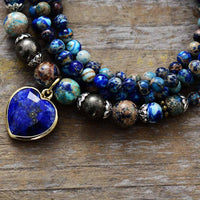 Jasper & Lapis Lazuli Heart Charm Wrap Bracelet–Necklace coiled on wood surface showing detailed bead mix and blue heart pendant. ALLORA JADE