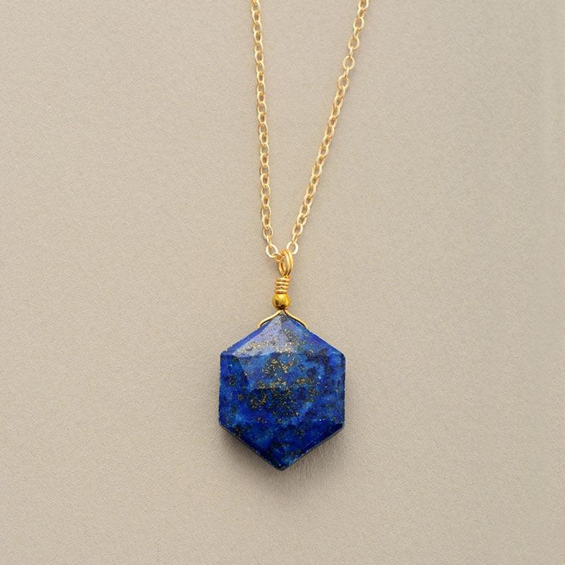 Close-up of Lapis Lazuli gemstone pendant with natural gold flecks on gold chain on grey background - Allora Jade