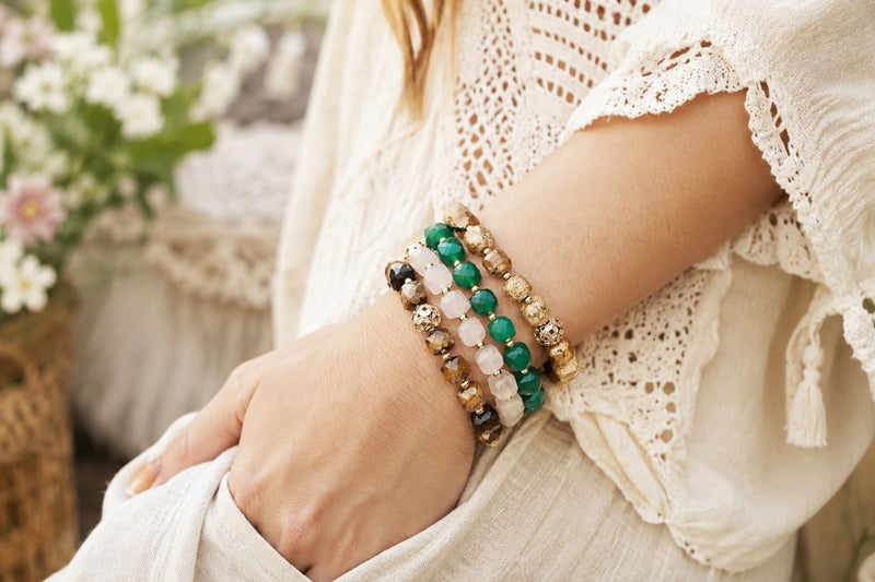 Layered gemstone elastic stretch bracelets styled with cream crochet and soft bohemian textures.