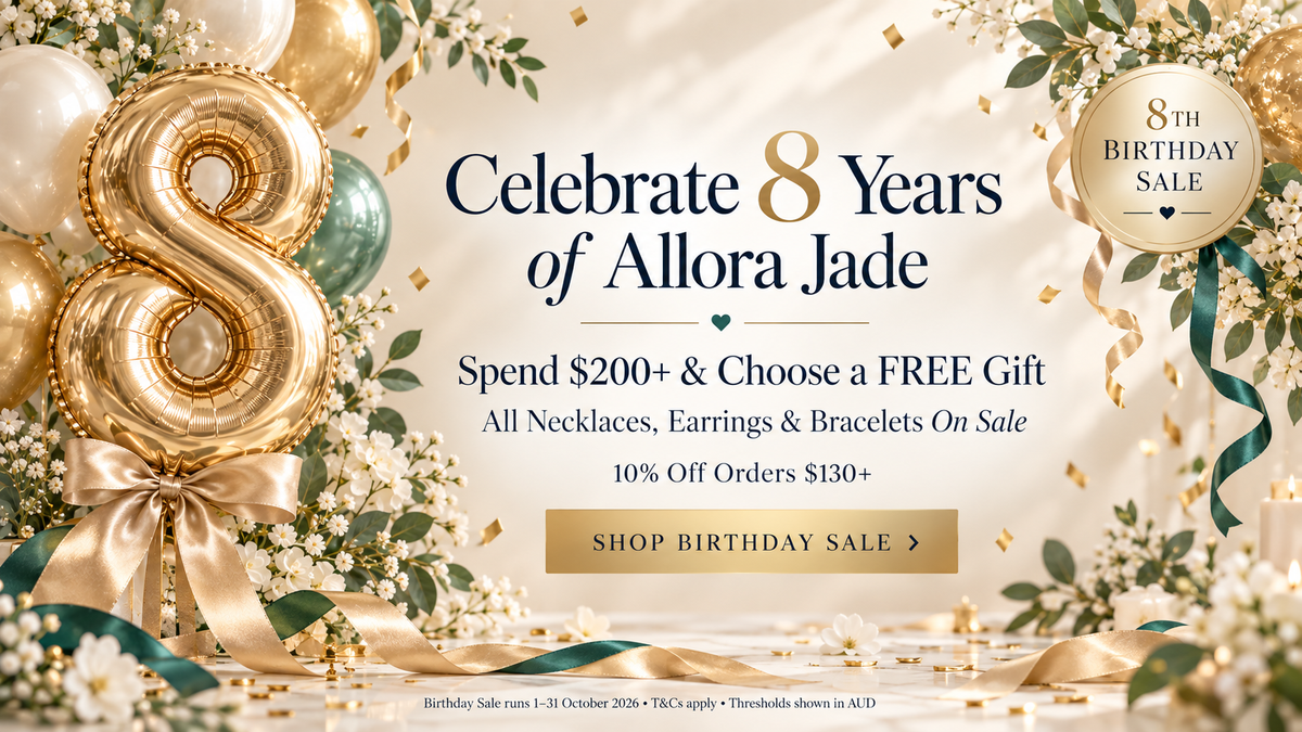Promotional birthday sale banner celebrating 8 Years of Allora Jade, featuring a large metallic gold balloon number 8, gold and teal balloons, white flowers, ribbons, and text offering a free gift and sale items on necklaces, earrings, and bracelets.