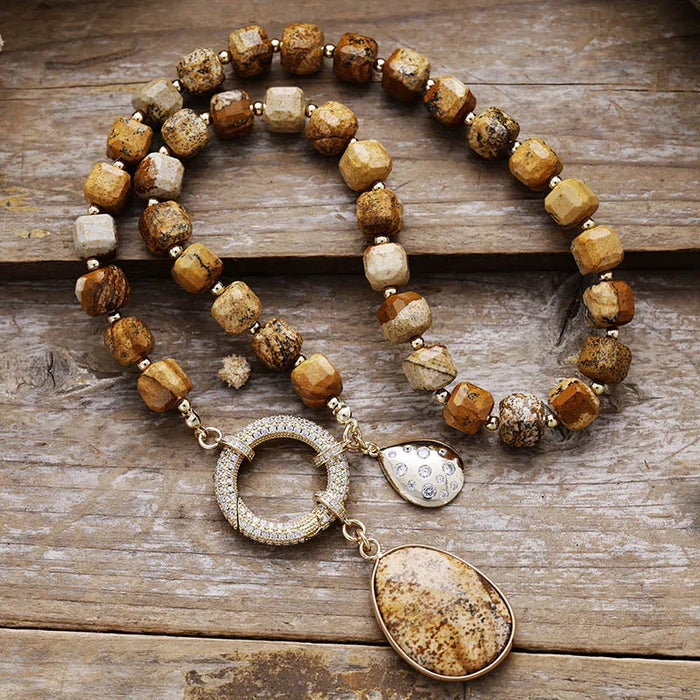 Necklace with brown and gold beads on a wooden surface. Picture Jasper Pavé Statement Necklace | ALLORA JADE