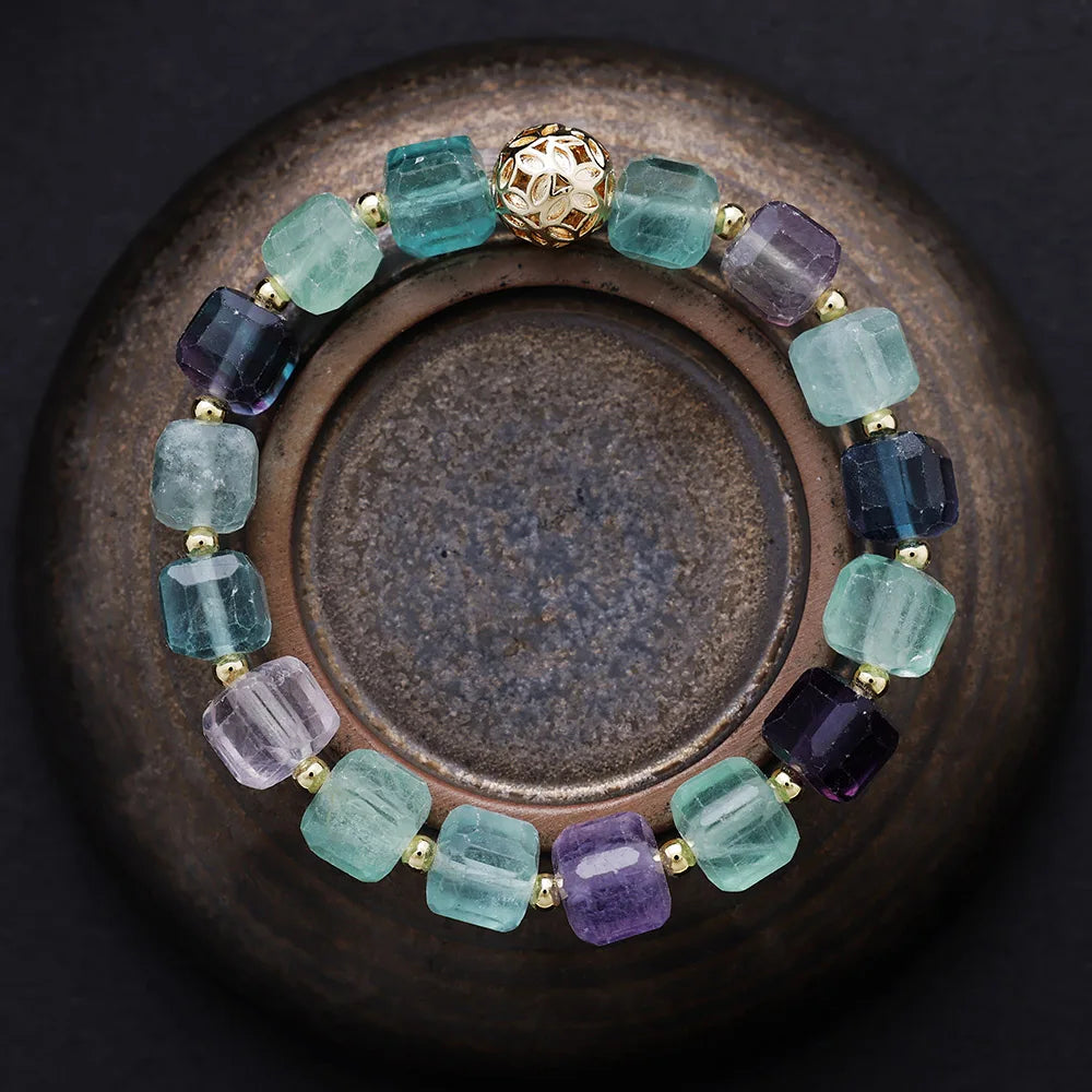 Multicolored beaded bracelet on a dark surface. Fluorite Faceted Cube Bracelet | ALLORA JADE