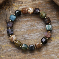 Multicolored beaded bracelet on a wooden surface. Indian Agate Faceted Cube Bracelet | ALLORA JADE