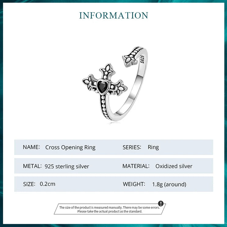 Silver cross opening ring with detailed design on a white background