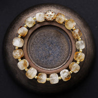 Bracelet with gold and clear beads on a dark background. Citrine Faceted Cube Bracelet | ALLORA JADE