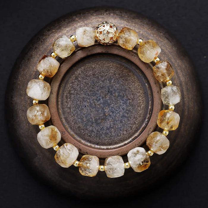 Bracelet with gold and clear beads on a dark background. Citrine Faceted Cube Bracelet | ALLORA JADE