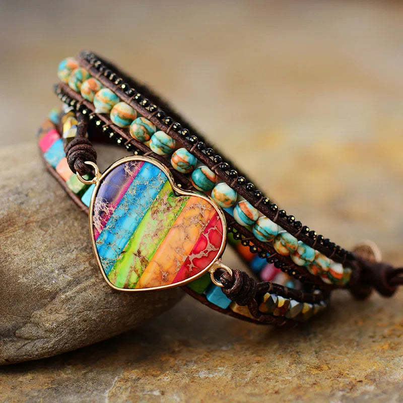 Multicolored beaded bracelet with a heart-shaped stone on a stone surface