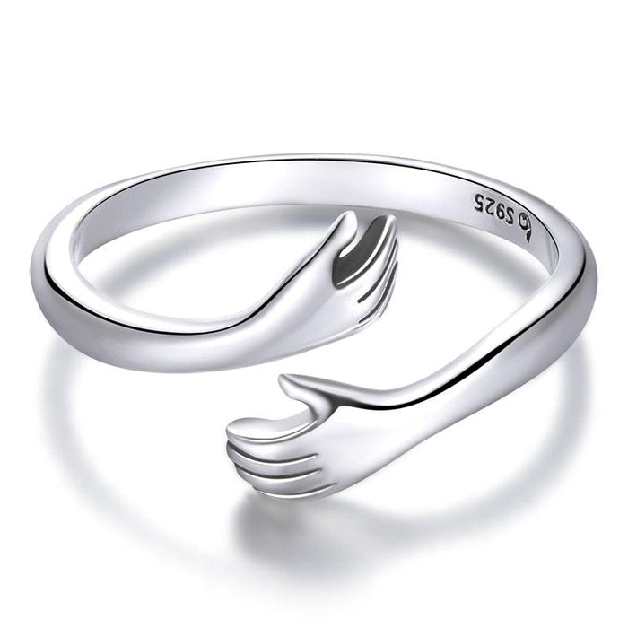 An elegant 'Loving Hug' sterling silver ring with an open band design that resembles a hugging gesture - Allora Jade