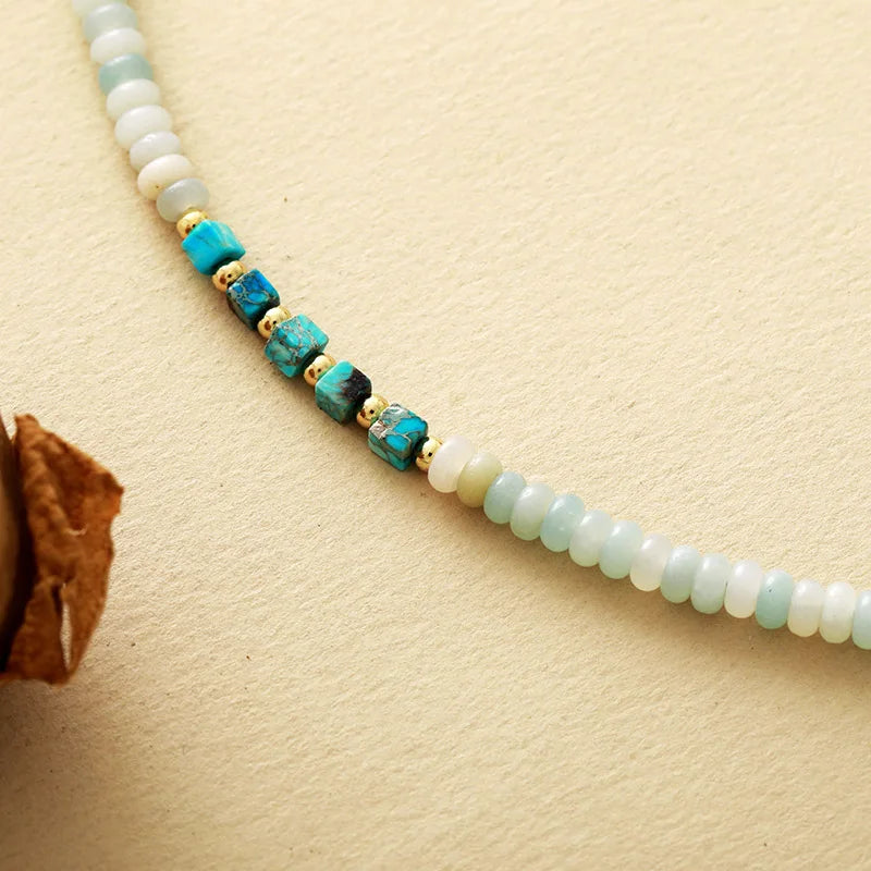 Necklace with turquoise and gold beads on a beige background