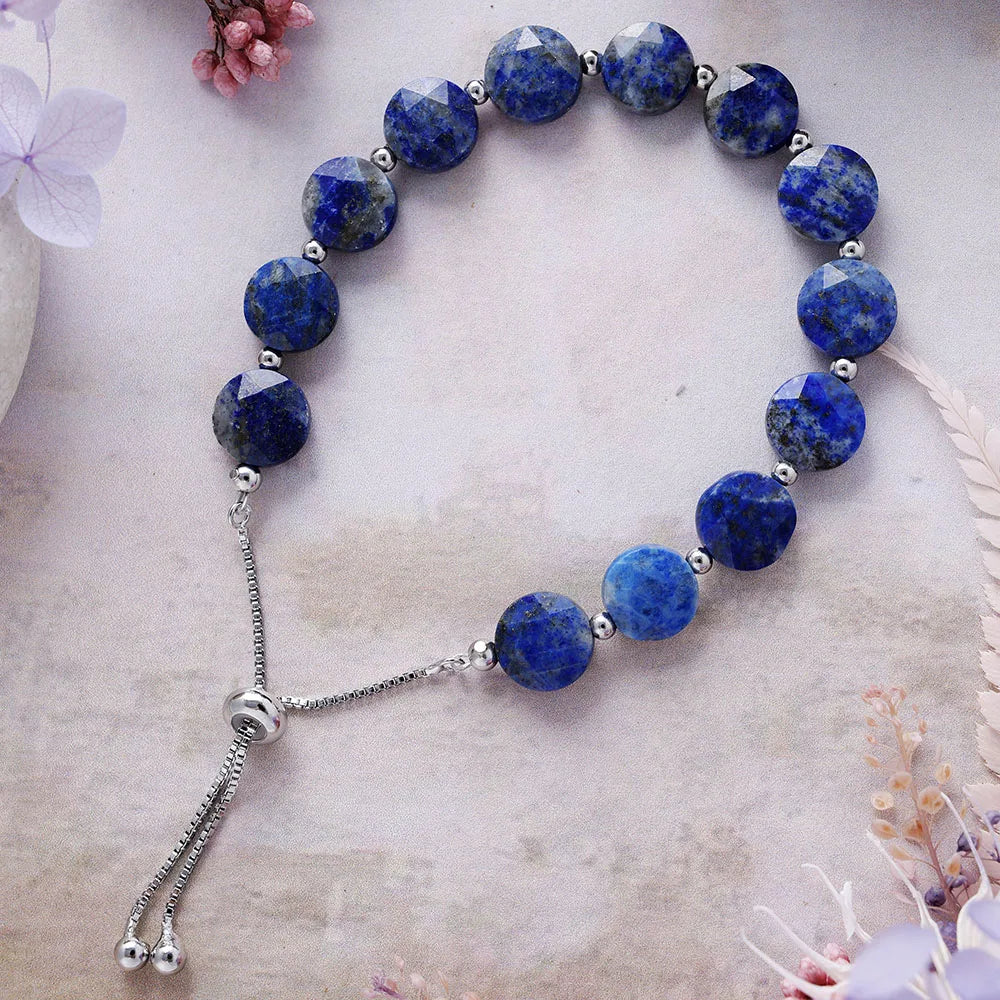 Blue beaded bracelet with silver accents on a light background