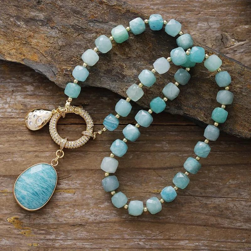 Turquoise coloured beaded necklace with gold accents on a wooden surface. Amazonite Pavé Statement Necklace | ALLORA JADE
