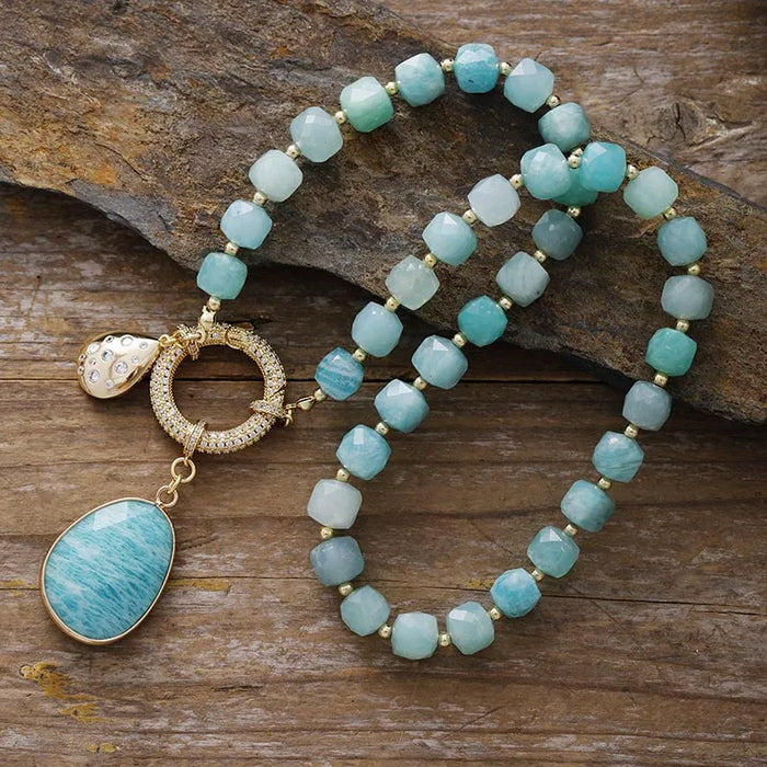 Turquoise coloured beaded necklace with gold accents on a wooden surface. Amazonite Pavé Statement Necklace | ALLORA JADE