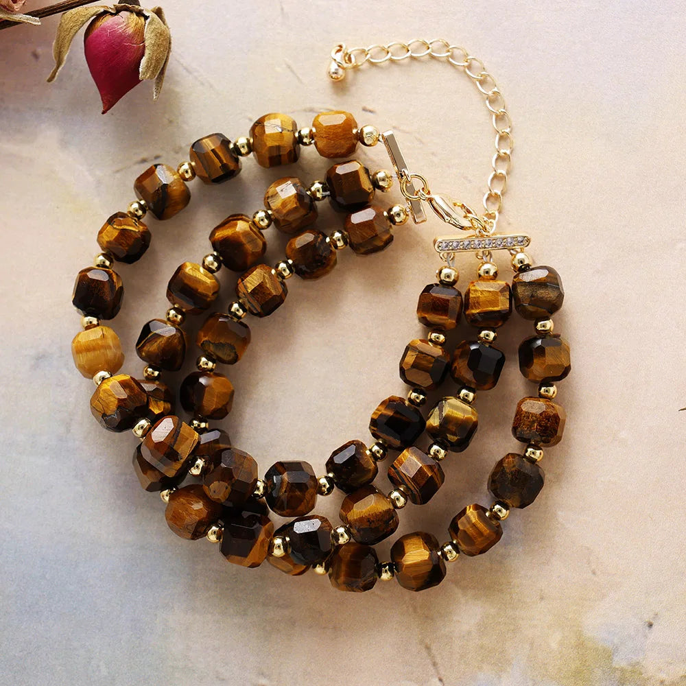 Brown beaded bracelet with gold accents on a light marble background