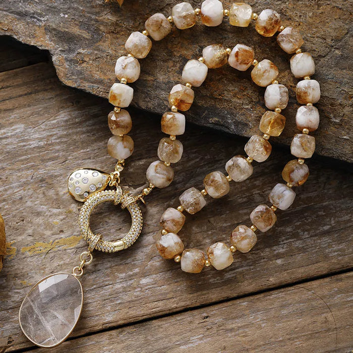 Necklace with gold and stone beads on a wooden surface. Citrine Pavé Statement Necklace | ALLORA JADE