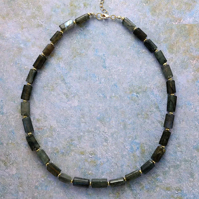 Necklace with dark Labradorite beads on a textured surface. ALLORA JADE