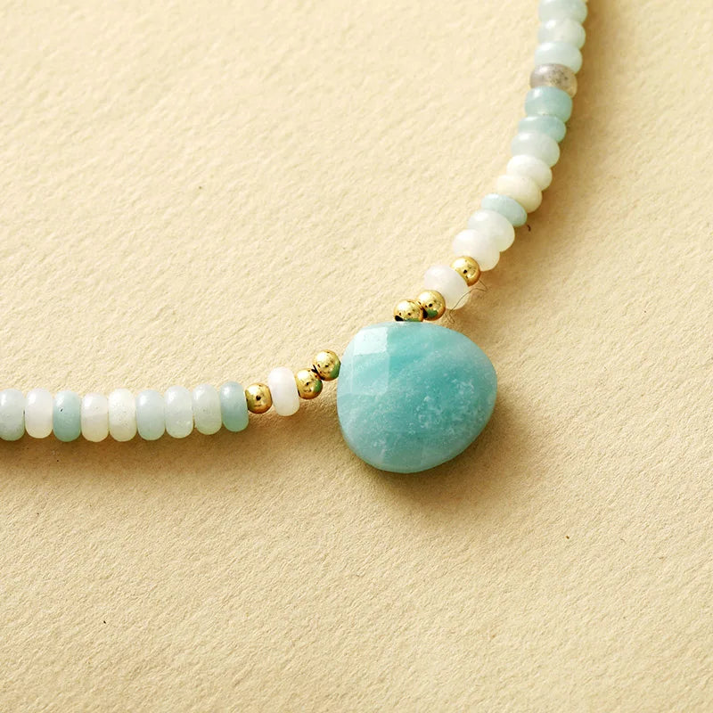 Necklace with Amazonite gemstone pendant and beads on a beige background