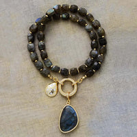 Beaded Necklace with gold accents and pendant on a beige background. Labradorite Pavé Statement Necklace | ALLORA JADE