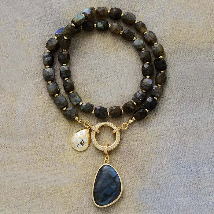 Beaded Necklace with gold accents and pendant on a beige background. Labradorite Pavé Statement Necklace | ALLORA JADE