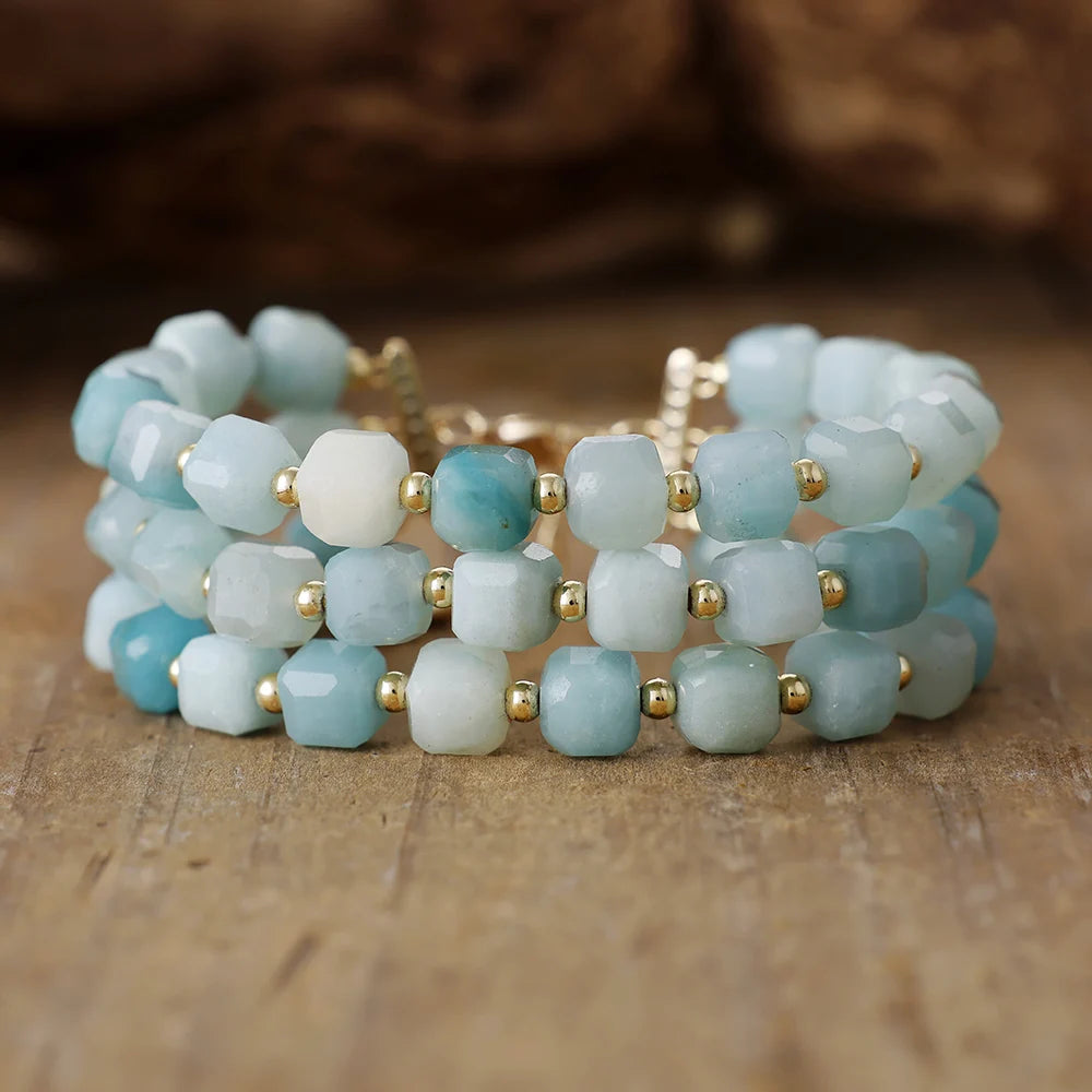 Stack of blue and gold beaded bracelets on a wooden surface