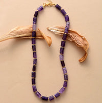 Purple beaded Amethyst Choker necklace with gold accents on a beige background - ALLORA JADE