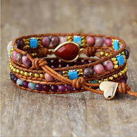 Multicolored beaded bracelet with heart button clasp, displayed on a textured surface