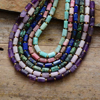 Colorful beaded necklace on a wooden surface. ALORA JADE