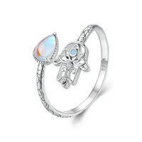 Silver ring with a teardrop-shaped gemstone and Hamsa hand design on a white background
